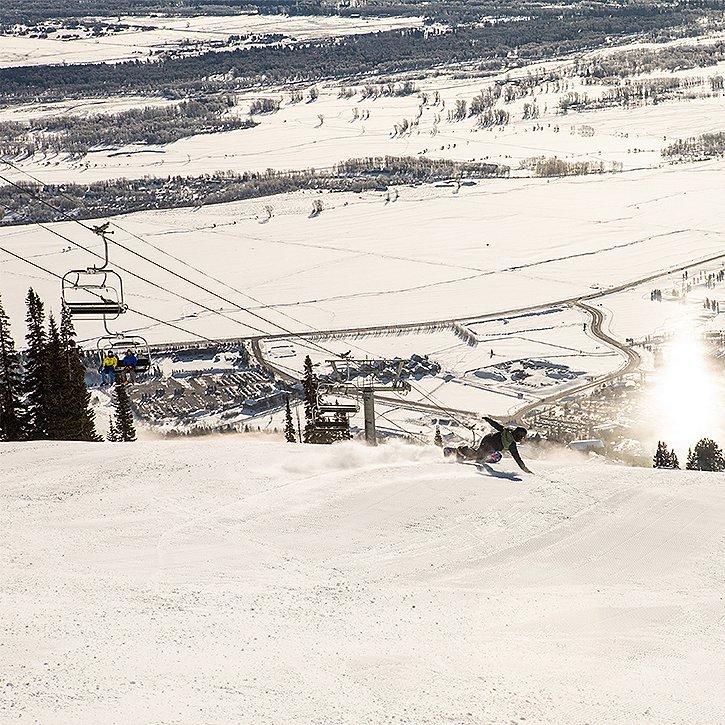 In a resort, a skier makes their way down the run, near the chairlift