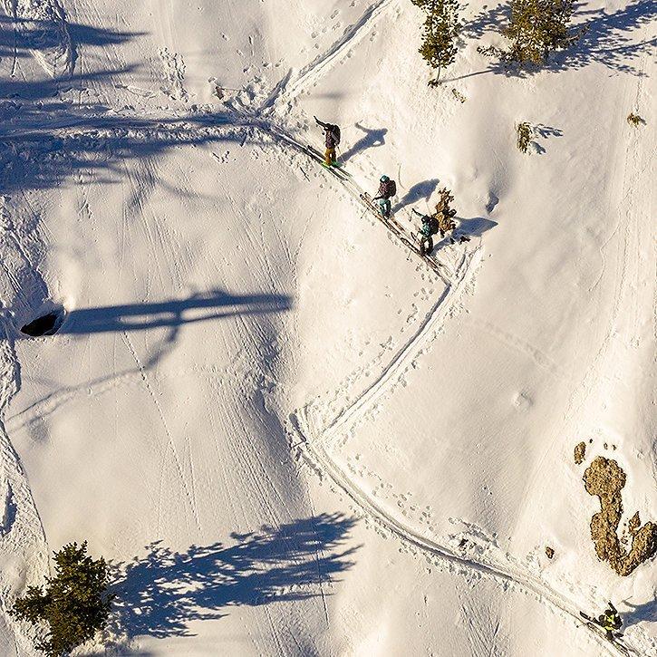 Ariel shot of a group of skiers skin their way up in the backcountry