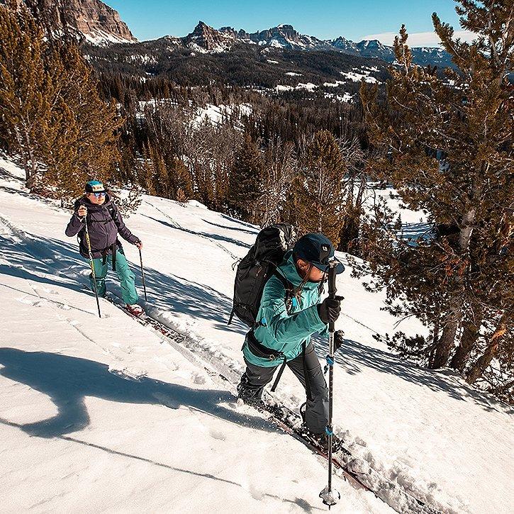 two skiers skinning up the mountain