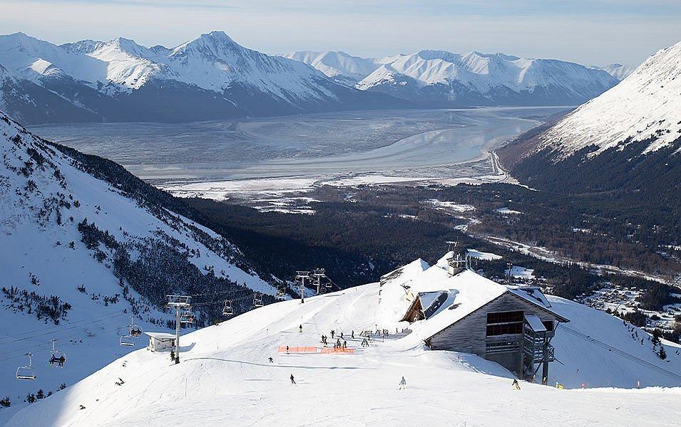 A beautiful landscape shot of Aleyeska Resort with a chairlift in the foreground and gorgeous mountains towering in the background. 
