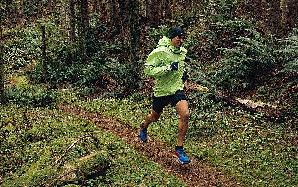 Man running on a forested trail. 