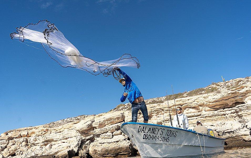 Marq throwing net into water.