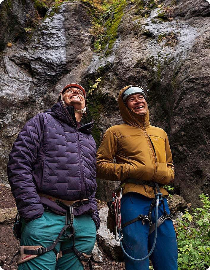 Two participants laughing and looking up at the climbing wall
