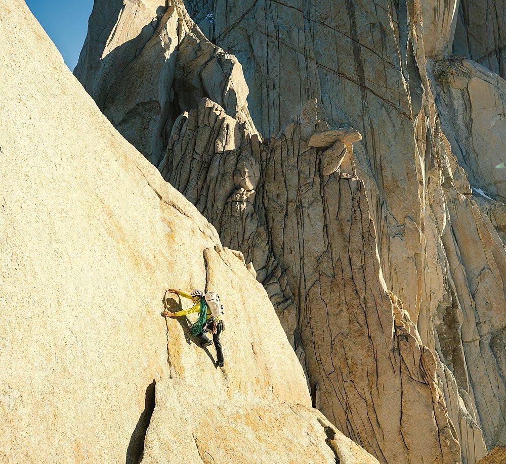 A climber makes their way up a route in sunny, bluebird conditions.