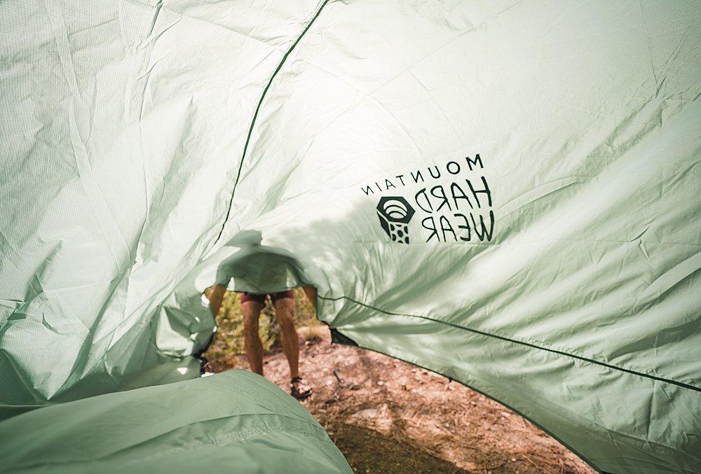 An obscure view of a figure and tent fly from underneath.