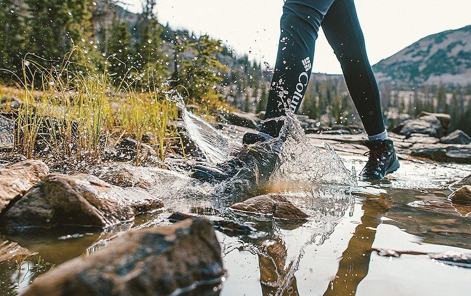 Close up of some one's feet walking through a muddy river. 