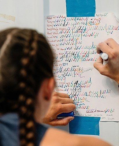 Black and white image of Alex Johnson, at home, holding her dog.