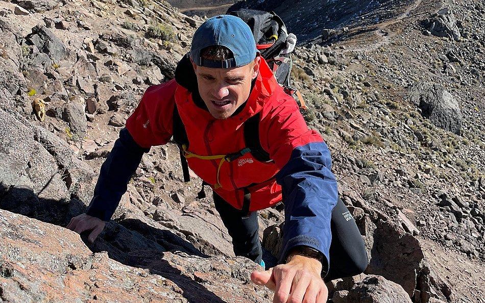 Scott Lehmann (he/him) traversing up a mountain