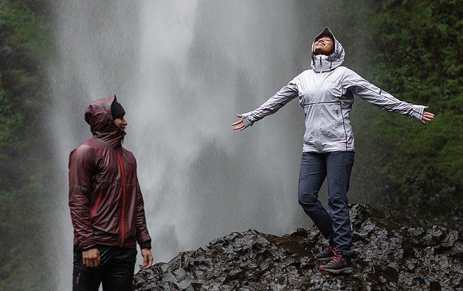 Deux personnes debout près d’une cascade portant des vestes de pluie Columbia Sportswear.