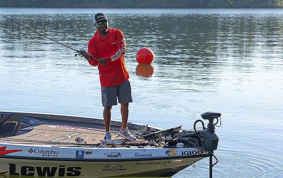 Mark Daniels Jr standing at the front of the boat as he casts out his line while wearing Performance Fishing Gear.