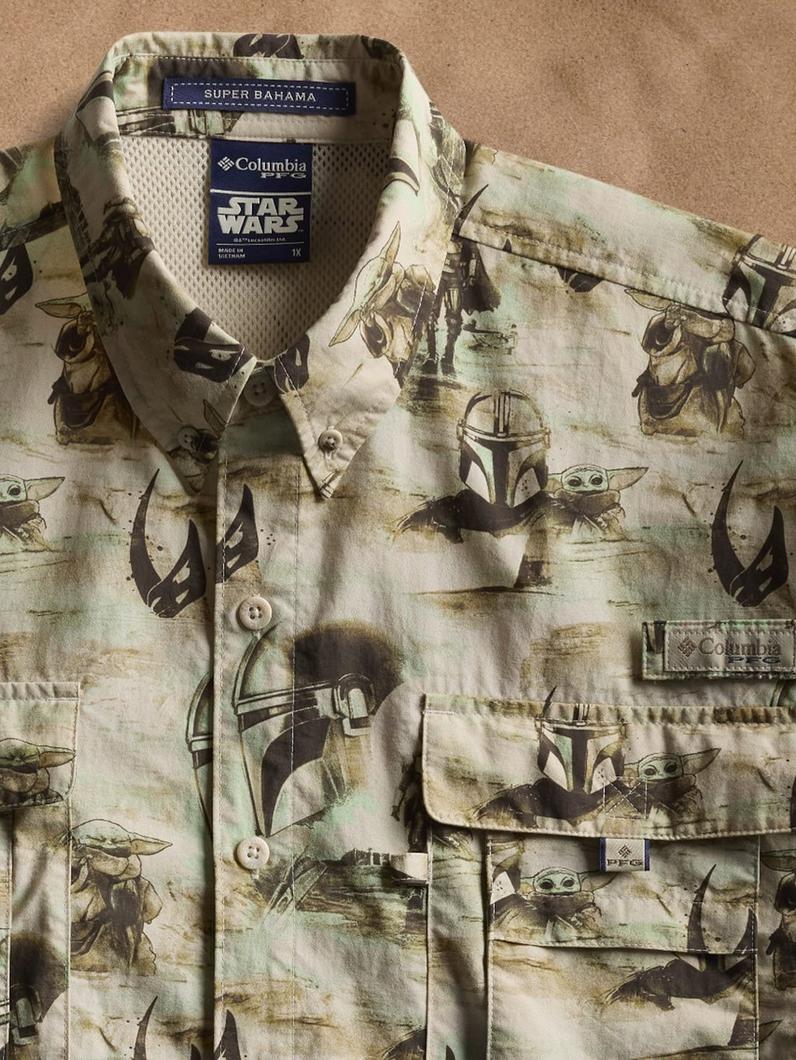 Short-sleeved button-up shirt with Star Wars character print in earth tones featuring chest pockets.