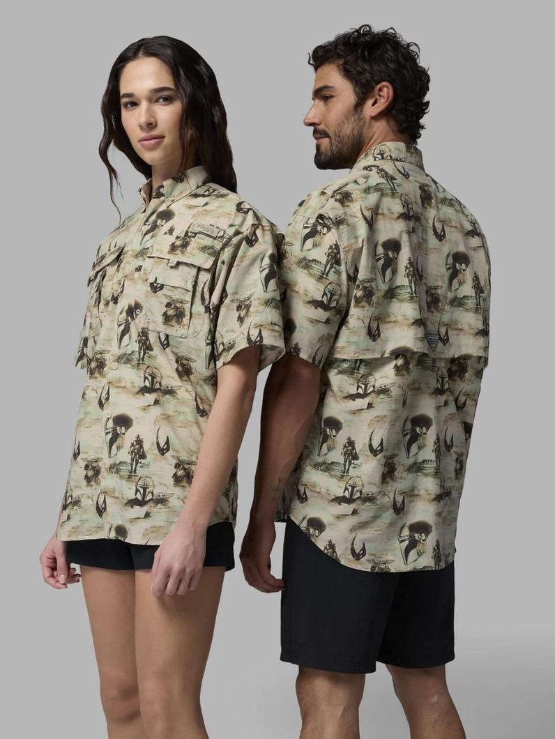 Two models wearing matching short-sleeve button-up shirts with a western-themed print featuring cowboys and horses.