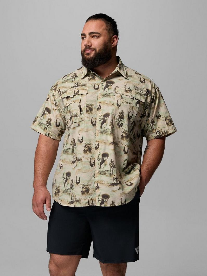 Man wearing short-sleeve button-up shirt with western-themed print featuring cowboys and cattle horns.