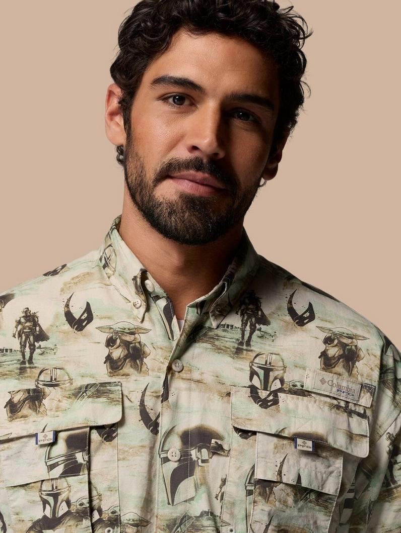 Man wearing button-down shirt with sci-fi character print featuring helmets and desert scenes.