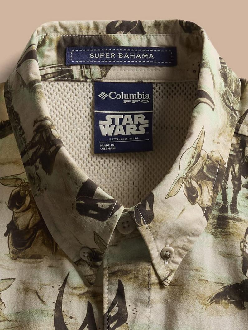 Short-sleeve button-up shirt with STAR WARS character print in earth tones, folded to show collar.