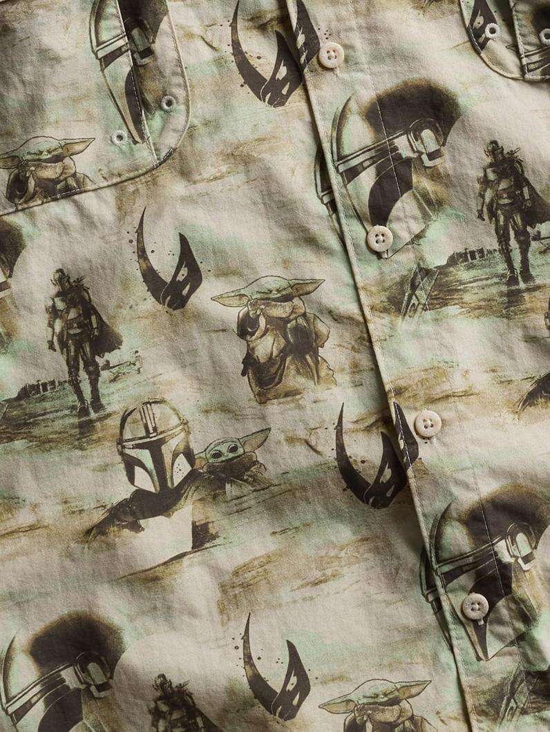 Button-up shirt with all-over print featuring sci-fi characters, helmets, and symbols in sepia tones.