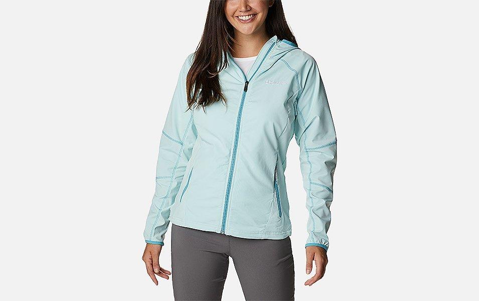 A woman models a light blue Columbia Sportswear Sweet As Softshell hooded jacket in a product shot with a white background. 