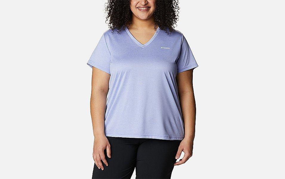A woman models a light purple Columbia Sportswear short sleeve plus-size v-neck shirt with a white background. 