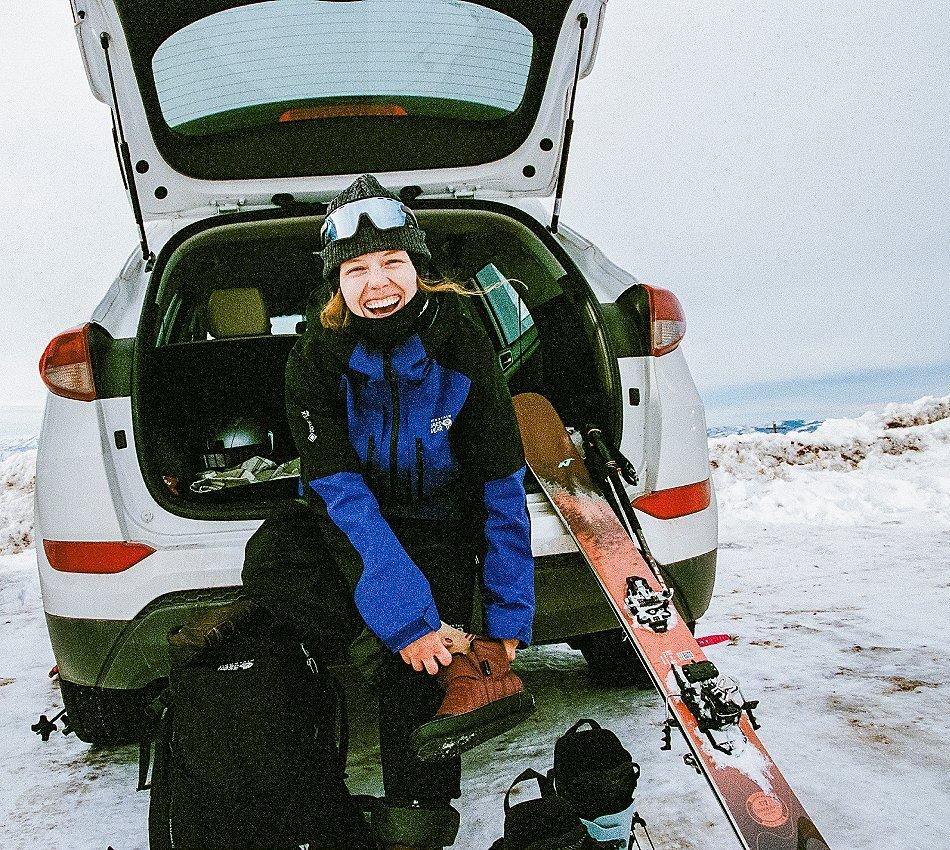 Erin Spong smiling in the back of a car while prepping to ski.