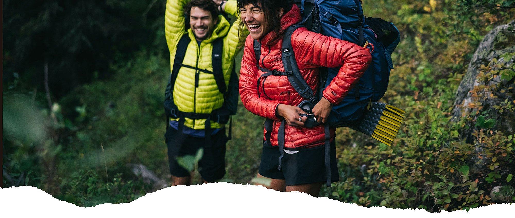 two backpackers adjusting their packs