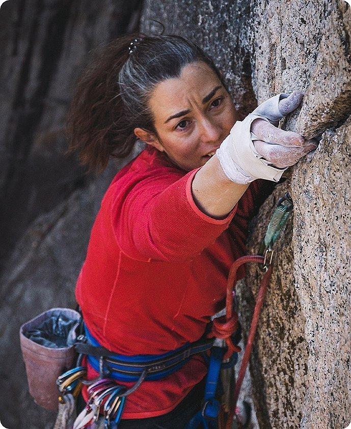 close up of Miranda reaching for a hold while climbing in Yosemite