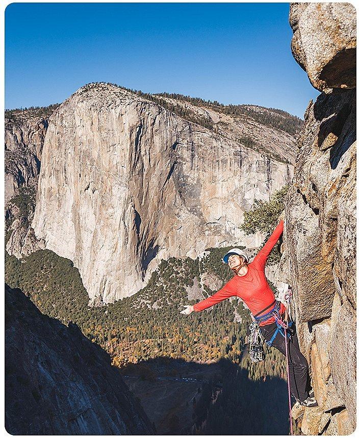 Miranda reaching out and smiling at the beautiful sights around her in Yosemite while climbing