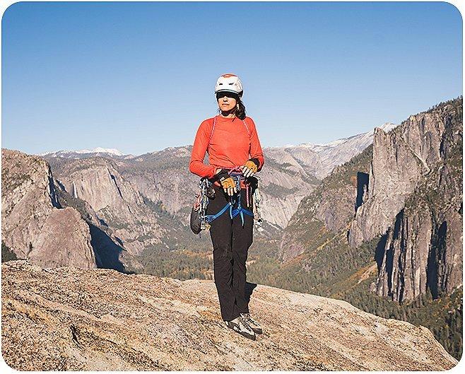 Miranda looks at the camera after climbing in Yosemite, standing at top of rock