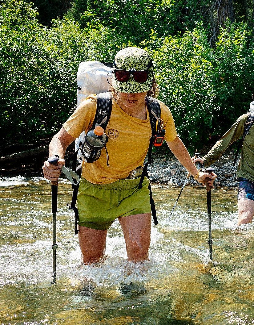 Hannah crosses a stream while on the backpacking trip.