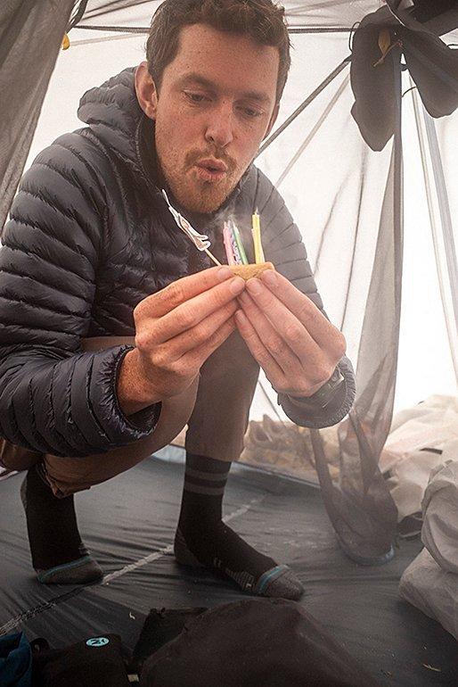 Brendan blowing out birthday candles in his tent.