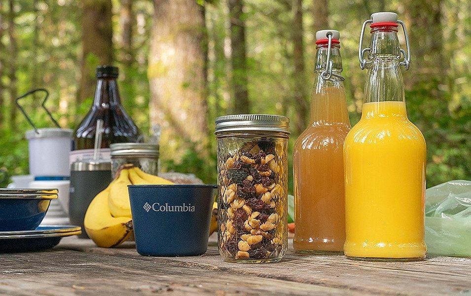 Food and drinks laid out on picnic table. 