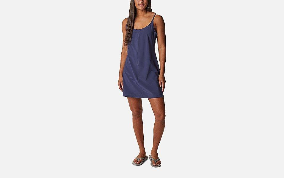 A product shot of a woman wearing a navy-colored Columbia Sportswear Pleasant Creek stretch dress with a gray background.