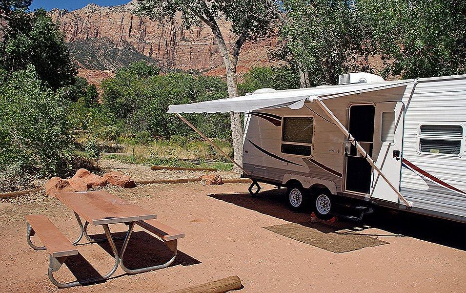 Parked camper with canopy extended out in a campsite in the southwest. 