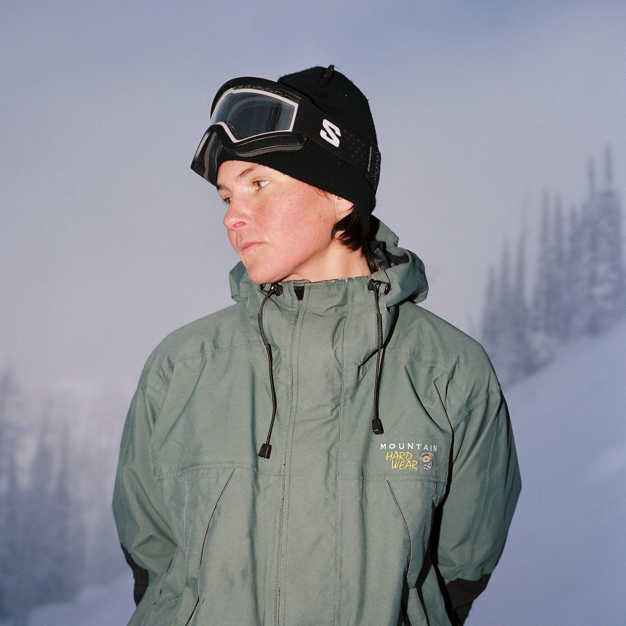 A foggy tree line barely visible behind her, professional snowboarder Emma Crosby soaks in a moment of calm.