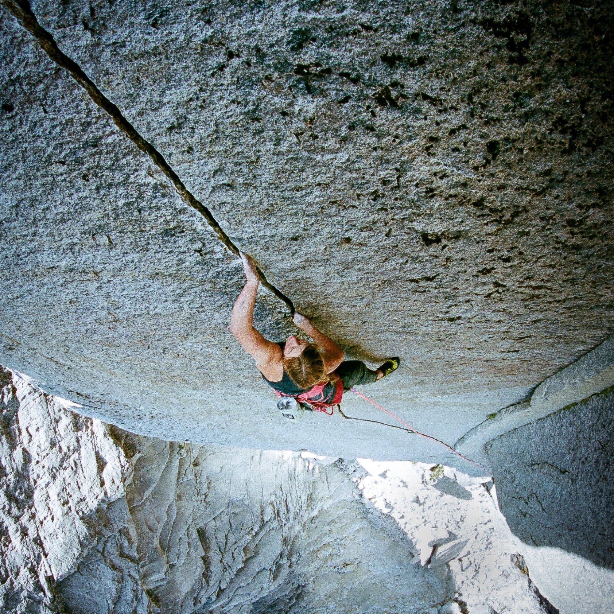High above jagged gray rocks, professional climber Flavie Cardinal continues to ascend the finger crack.