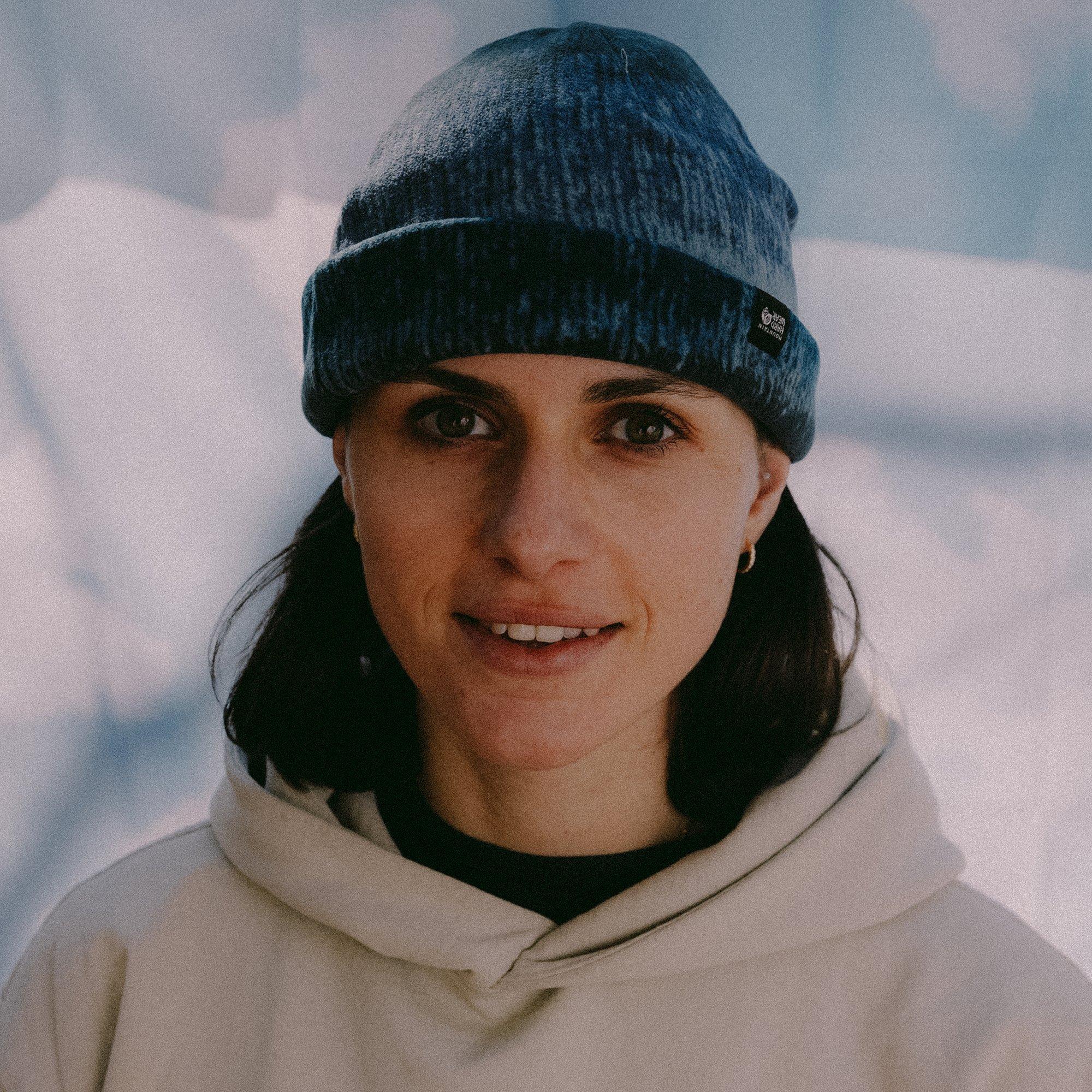 Paused in front of a snow drift, the profession climber Nina Arthaud is captured with a candid grin.