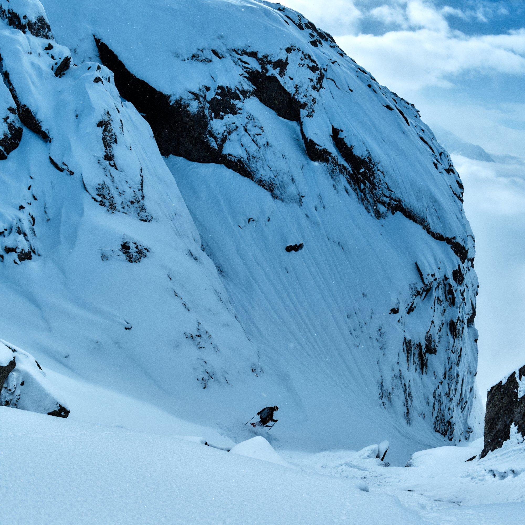 Seemingly miniscule compared to the jagged face he flies past, professional ski alpinist Vivian Bruchez carves down.