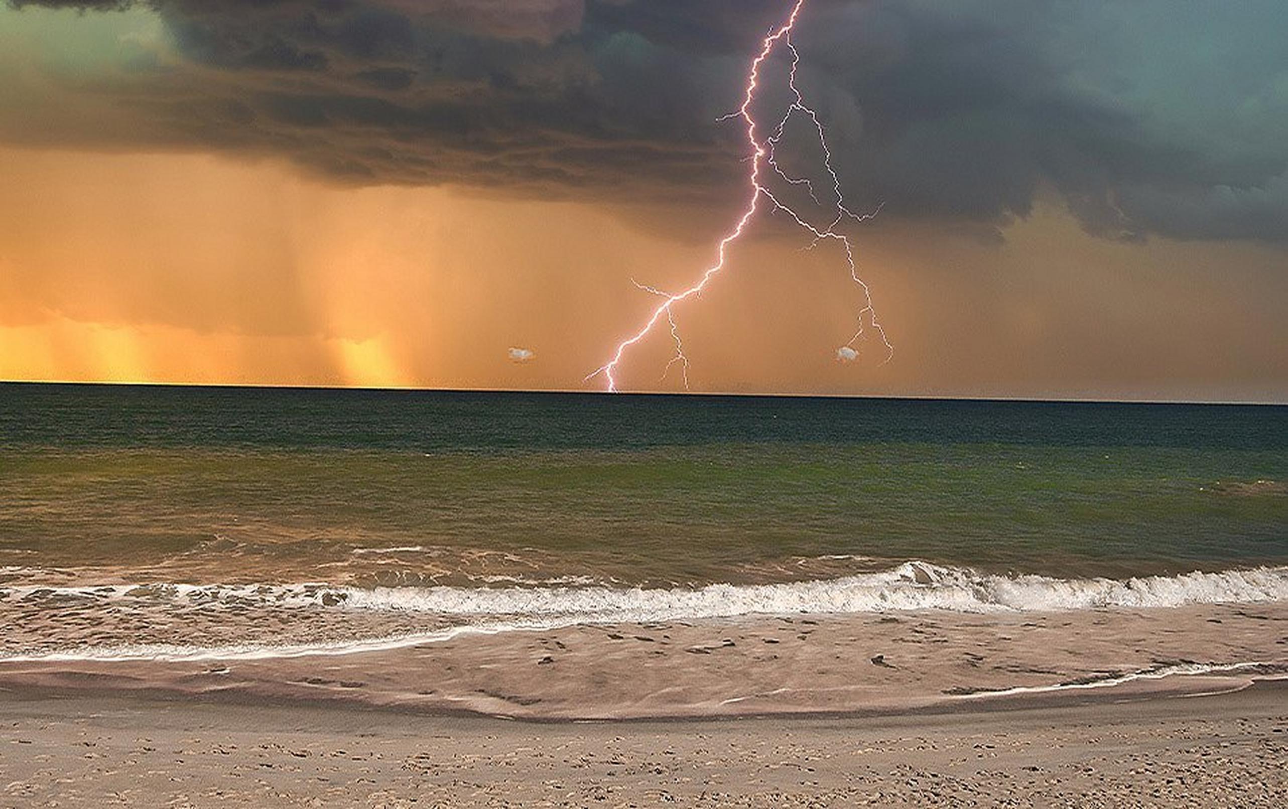 LIghtning striking in the distance over the shore