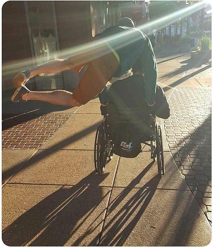 Ethan pushing his dad in the wheelchair, jumping for joy
