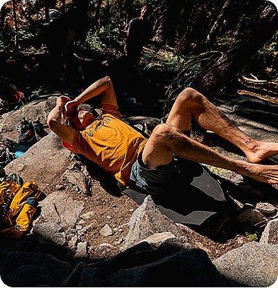 Ethan Pringle taking a break from climbing hunched over