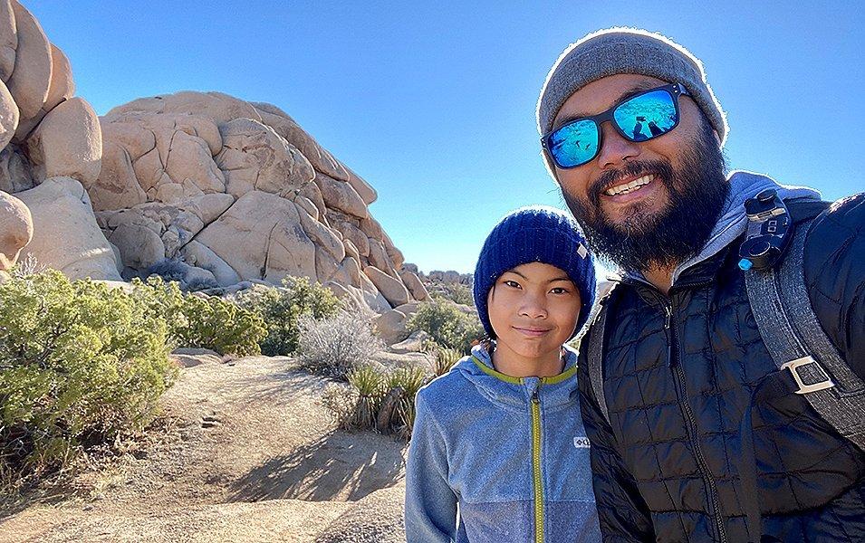 Father and daughter poising near a rock outcropping. 