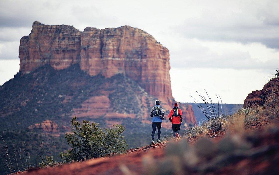 Two runners running on a trail.
