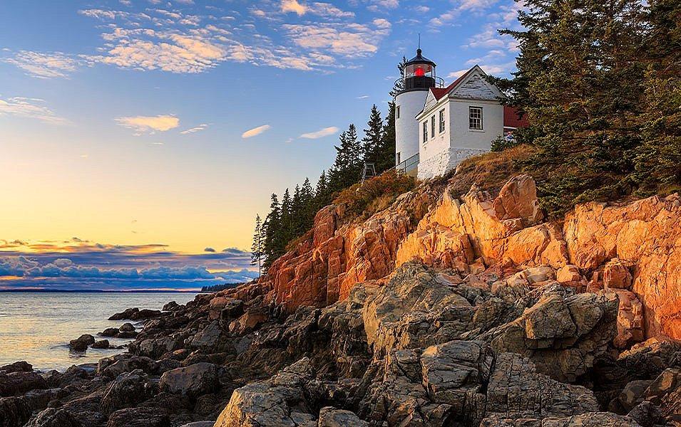 A lighthouse towers over the ocean shore in Maine’s Acadia National Park.
