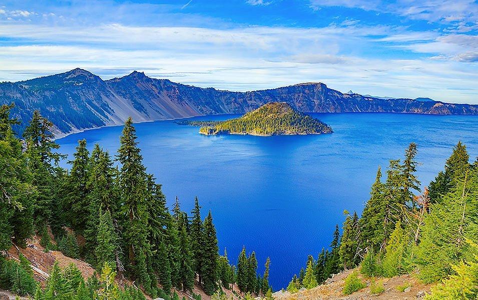 A stunning blue lake is pictured surrounded by mountains in this scenic shot of Oregon’s Crater Lake National Park.