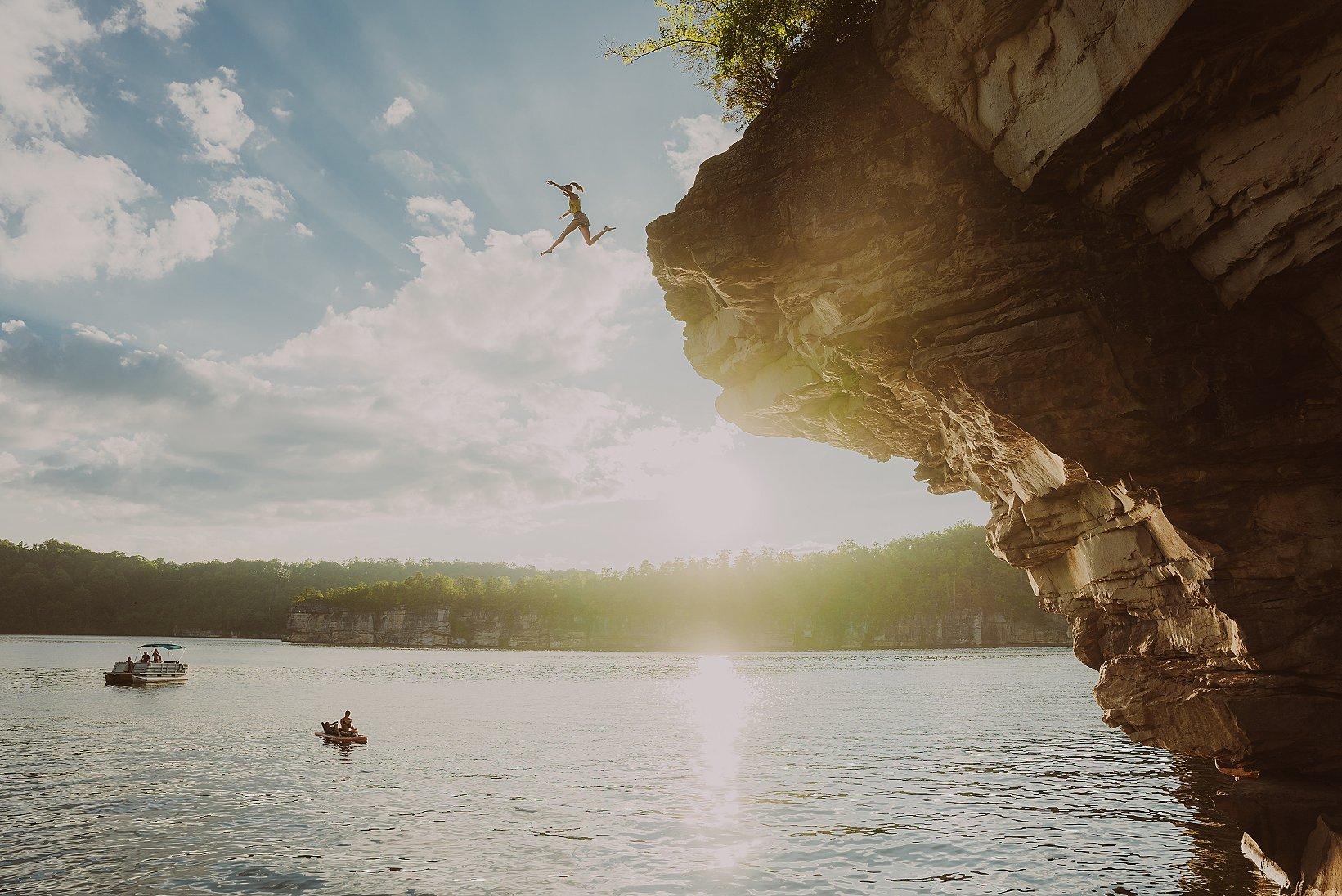 Rebekah Mull jumping into the water after bouldering high above.