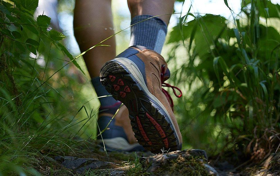 Legs of a hiker in Columbia Sportswear hiking boots walking through tall grass