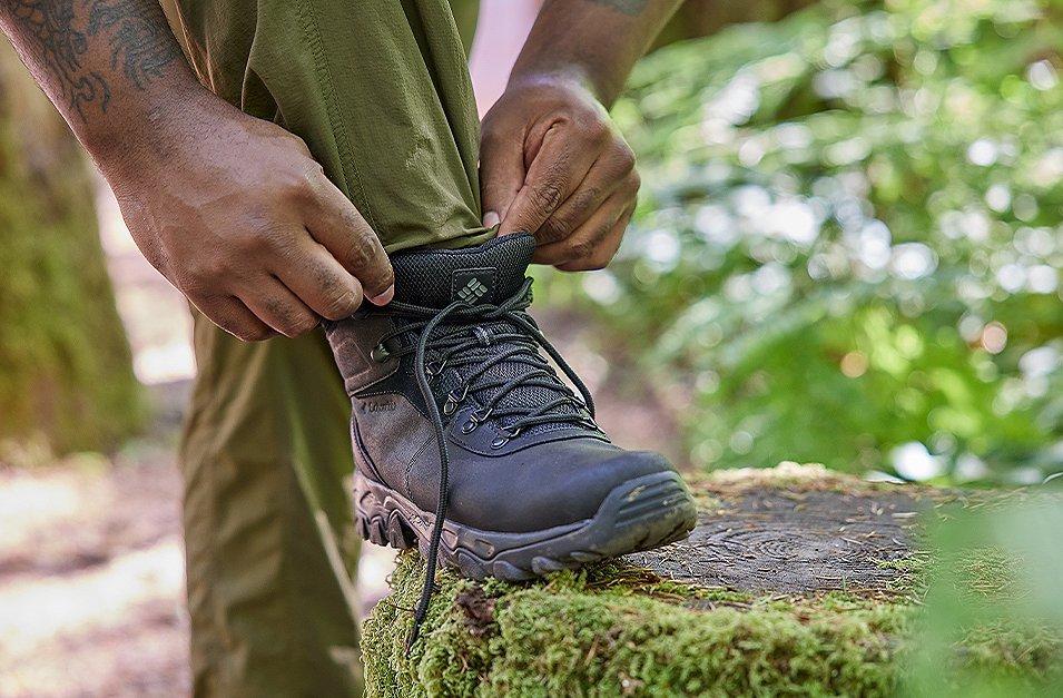 Legs of a hiker adjusting Columbia Sportswear Hiking boots. 