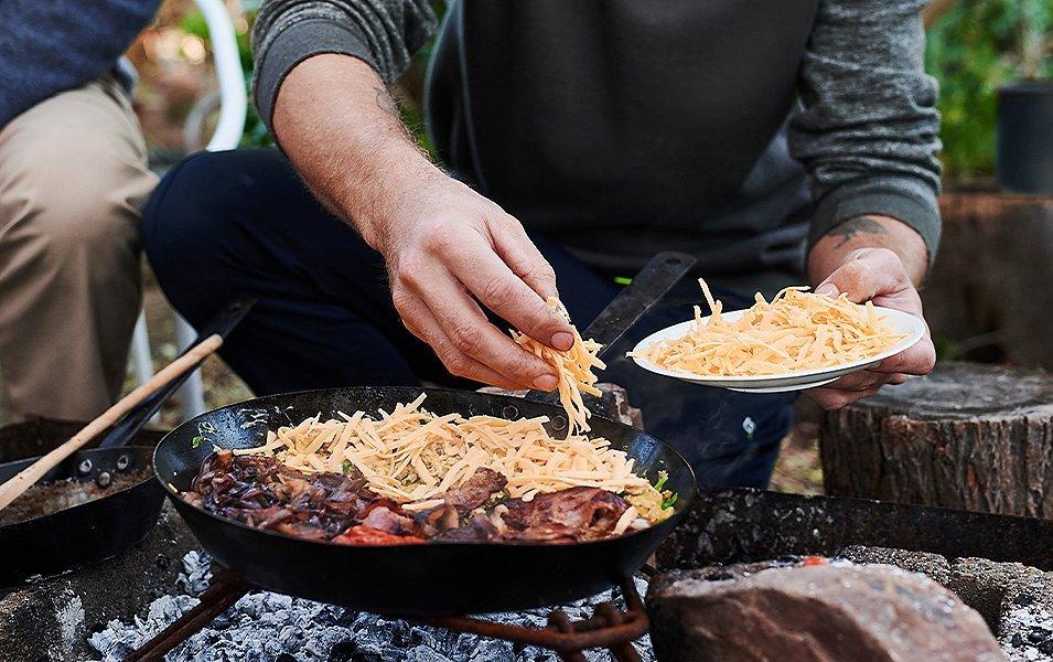 Person cooking over a skillet. 