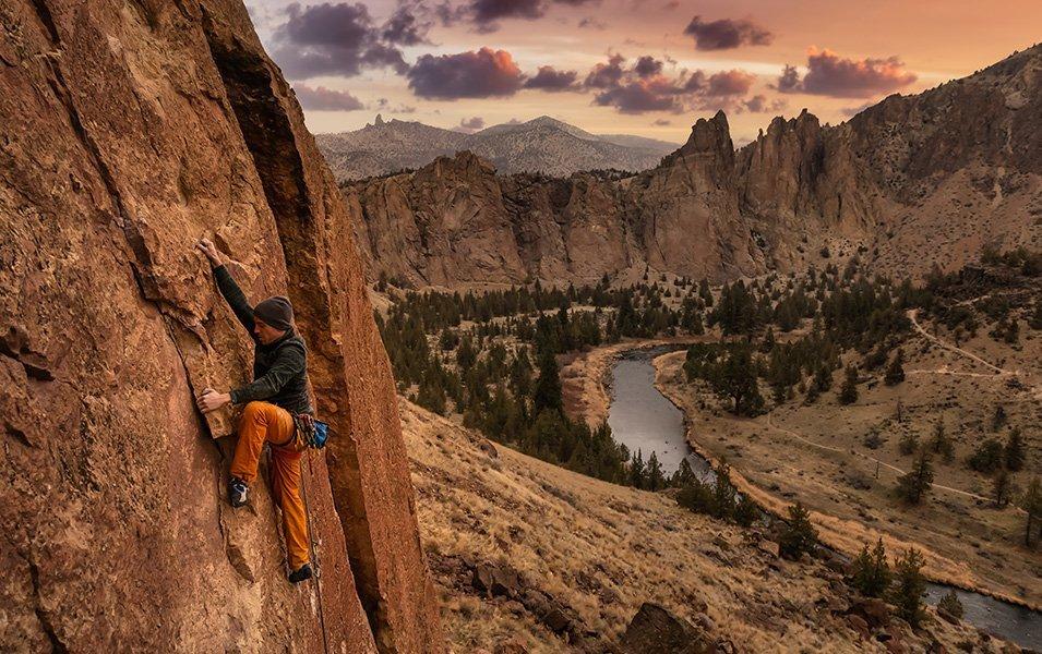 High above the river, a climber wrestles with his next move. 