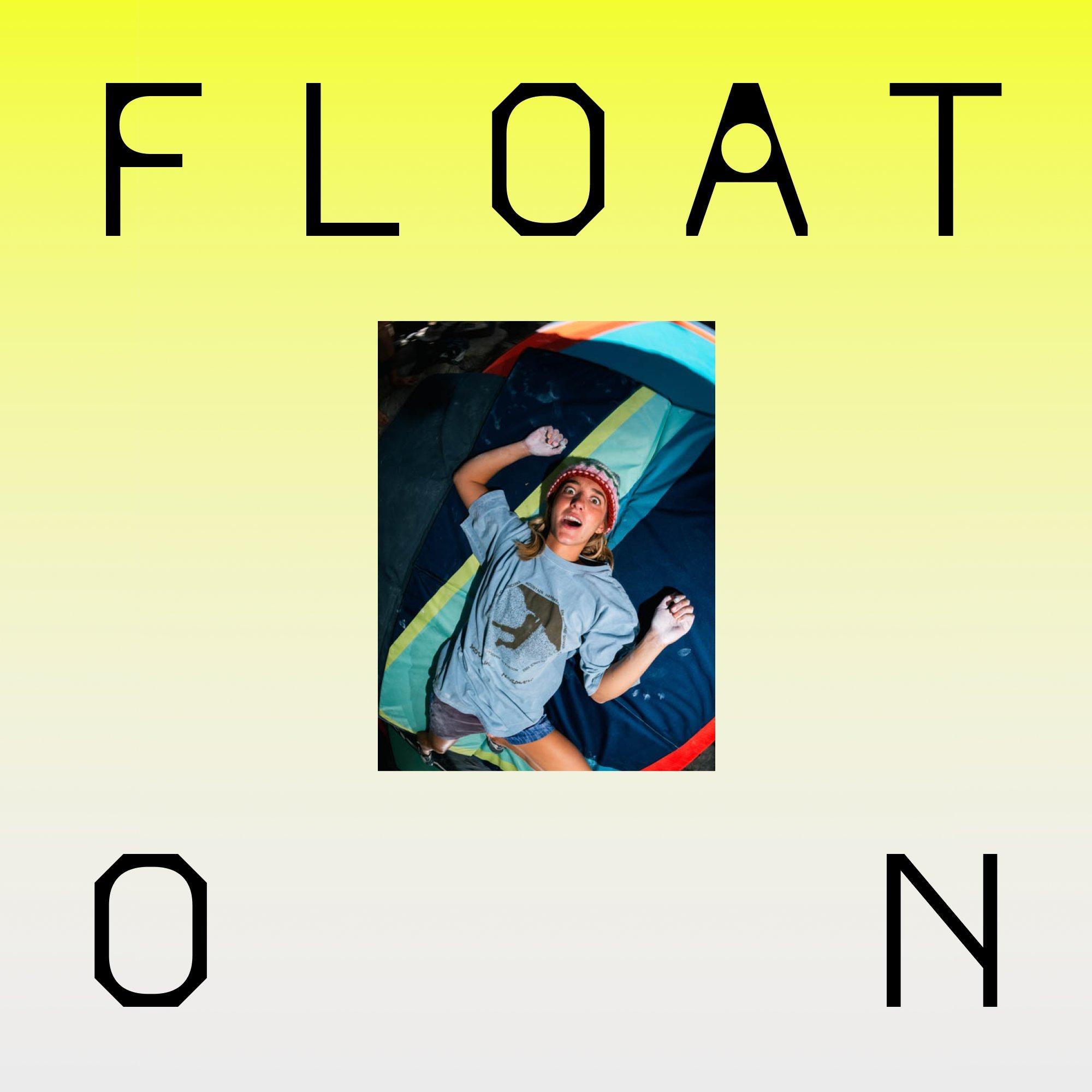 A woman in a Mountain Hardwear graphic t-shirt, freshly landed on a crash pad, makes a silly wide-eyed face at the camera. Text reads "FLOAT ON"