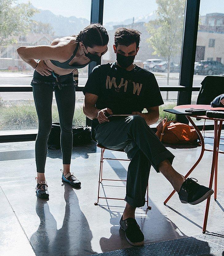 Josh and Kyra looking at footage of Kyra climbing, reviewing, seeing what can be improved